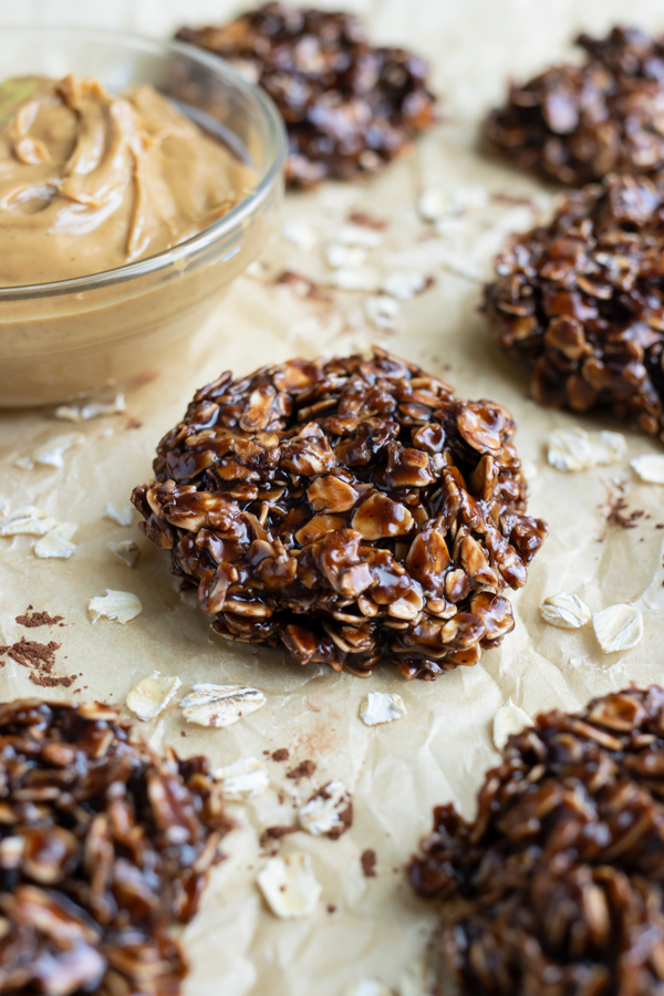 No-bake oatmeal cookies are set on parchment paper on the counter.