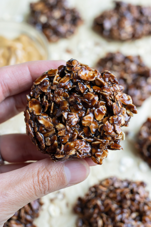A chocolate no-bake cookie is lifted up by a hand.