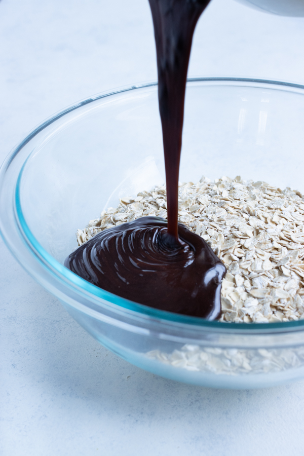 Chocolate and peanut butter mixture is poured over oats.
