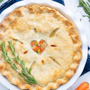 A golden turkey pot pie is shown on the counter and served with fresh herbs.
