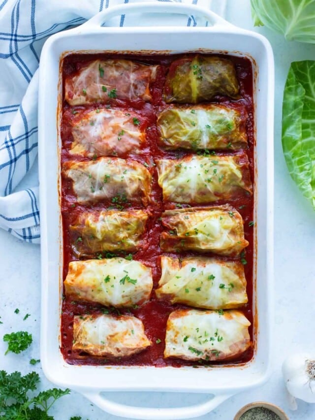 Traditional stuffed cabbage rolls with beef are served in a white baking dish.
