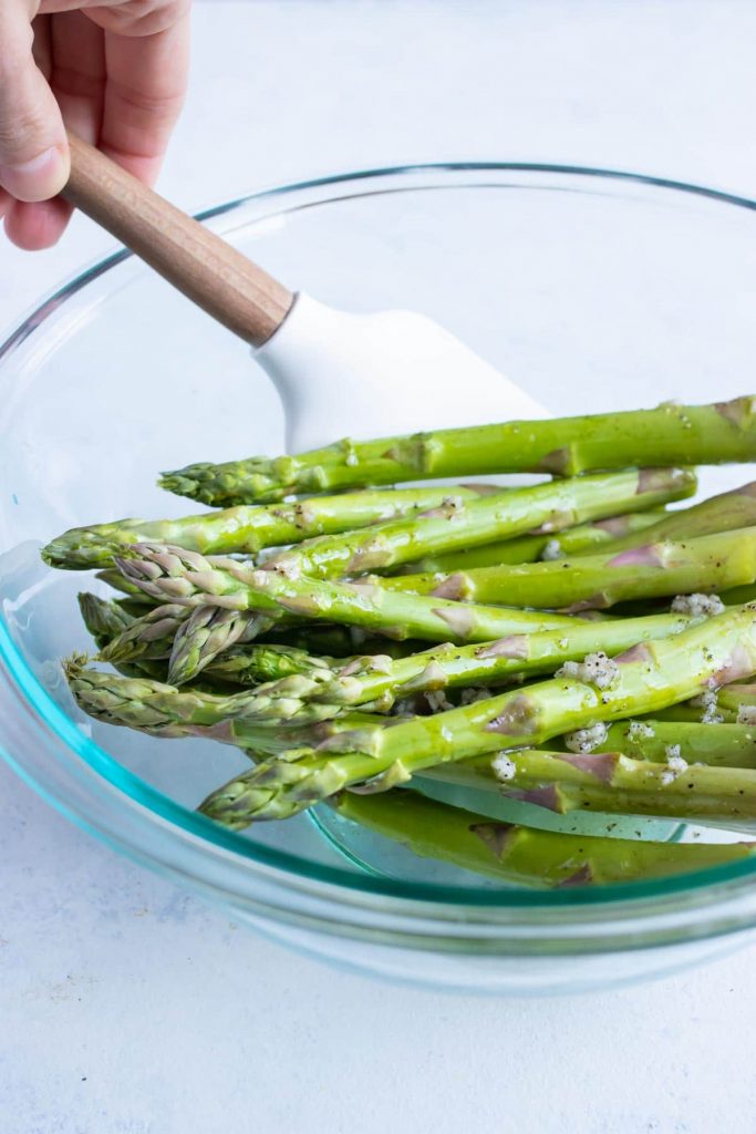Asparagus is covered in oil mixture.