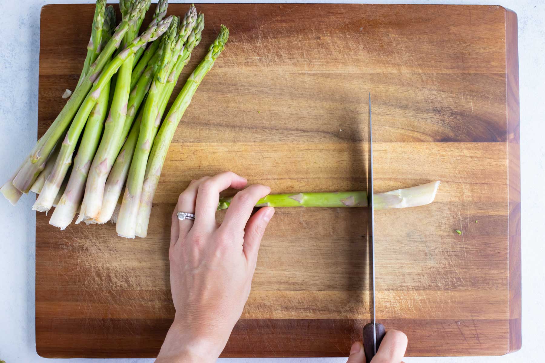 Asparagus stalks are cut with a knife.