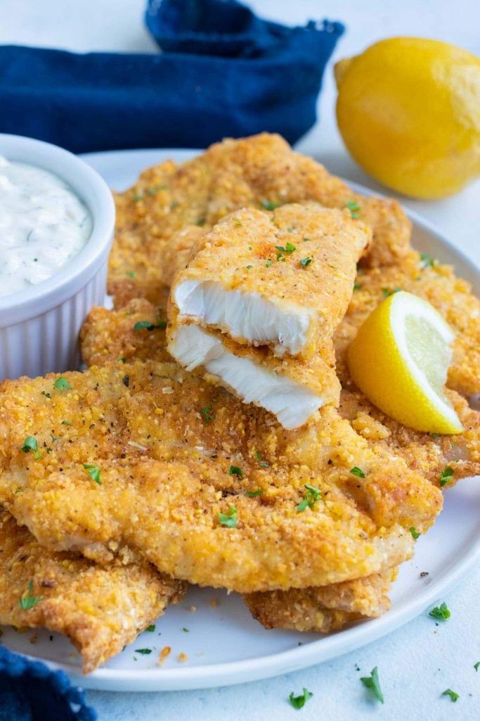 Breaded fish made in the air fryer is served on a white plate.
