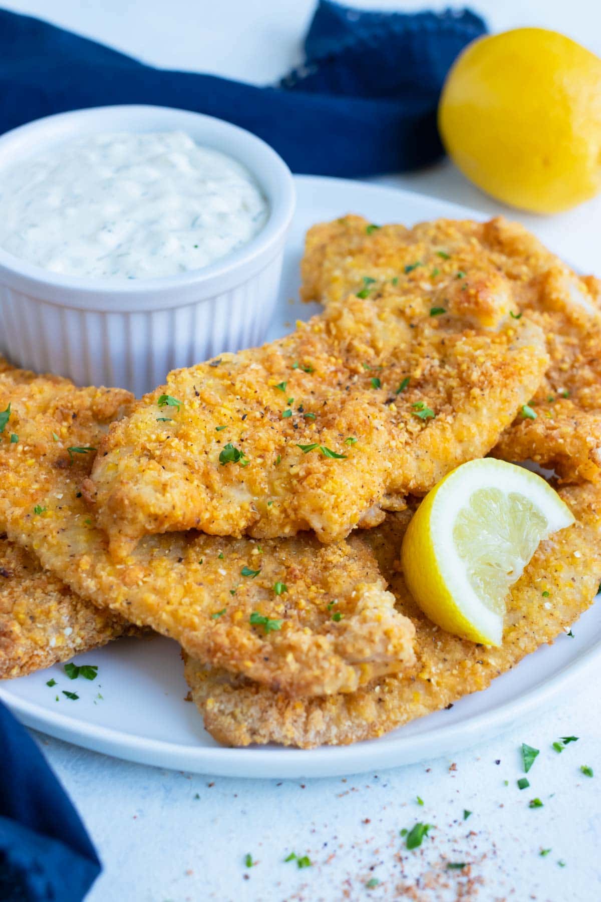 A few air fryer fish are shown on a white plate.