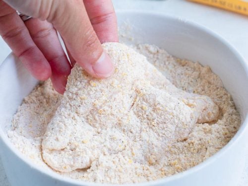 The fish fillets are coated in a cornmeal and flour mixture.