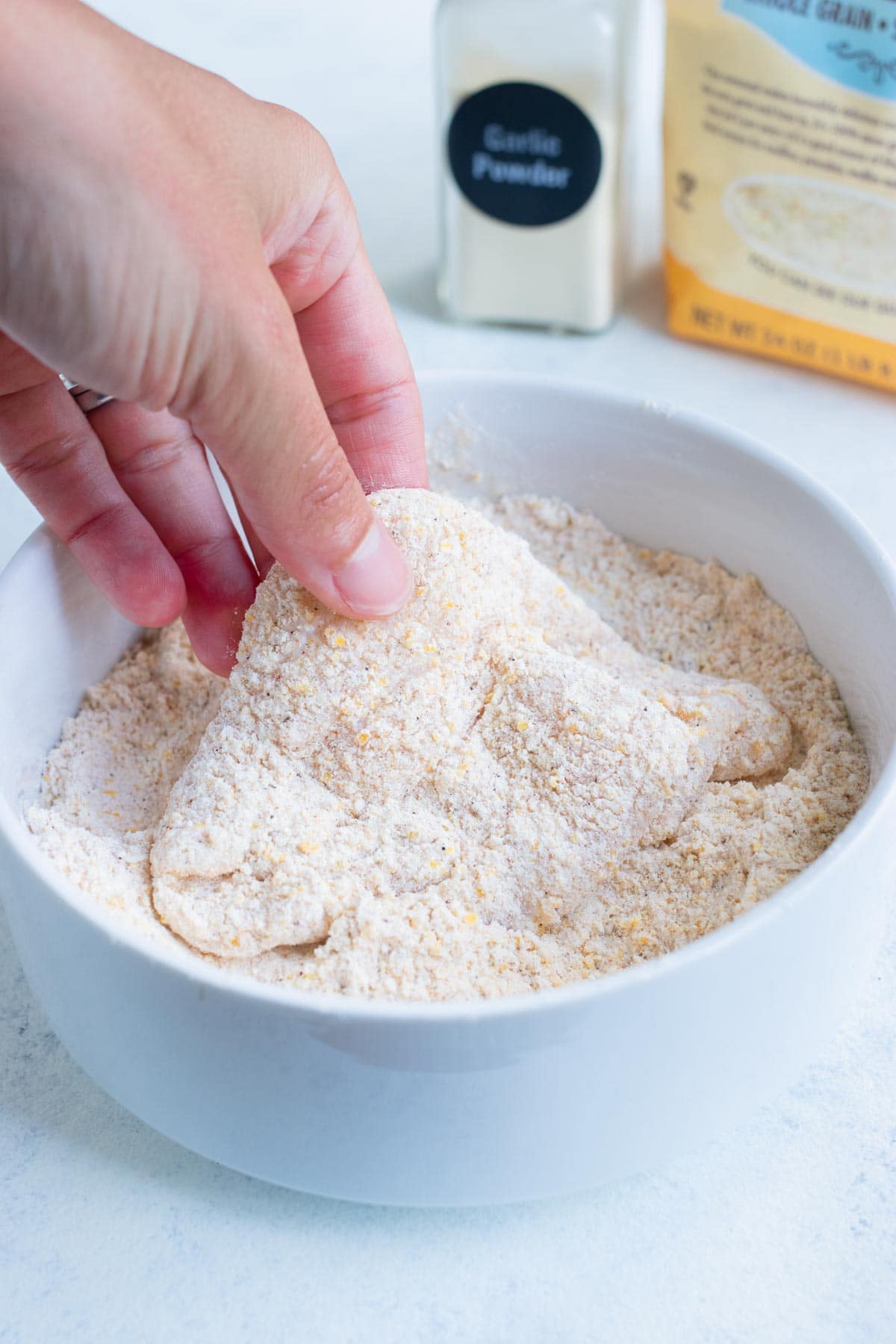 The fish fillets are coated in a cornmeal and flour mixture.