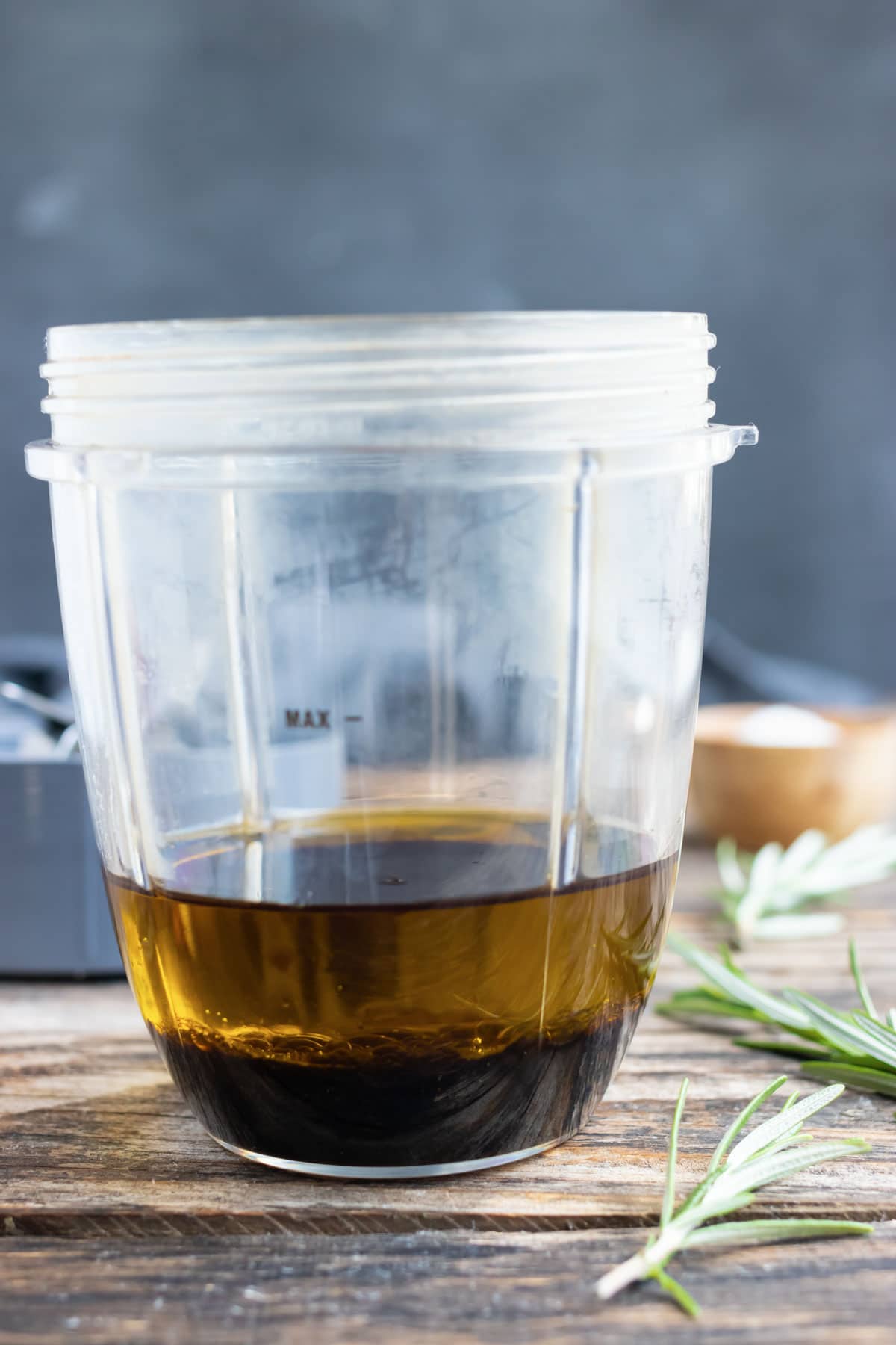 A small blender with balsamic vinegar, olive oil, and honey showing you how to make balsamic vinaigrette at home.