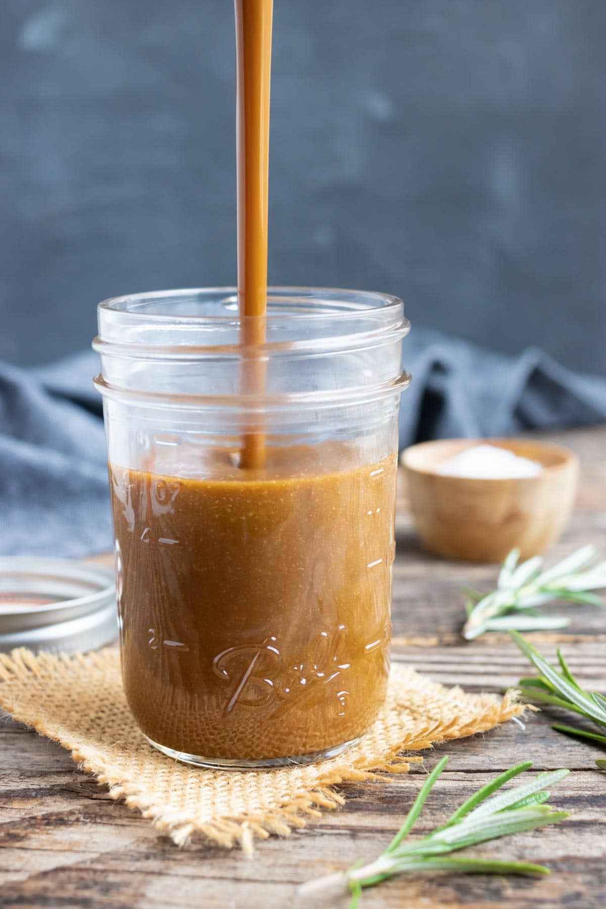 An easy balsamic vinaigrette recipe being poured into a clear mason jar.
