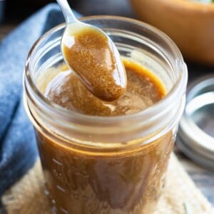 A small spoon scooping out a serving of a homemade balsamic salad dressing.