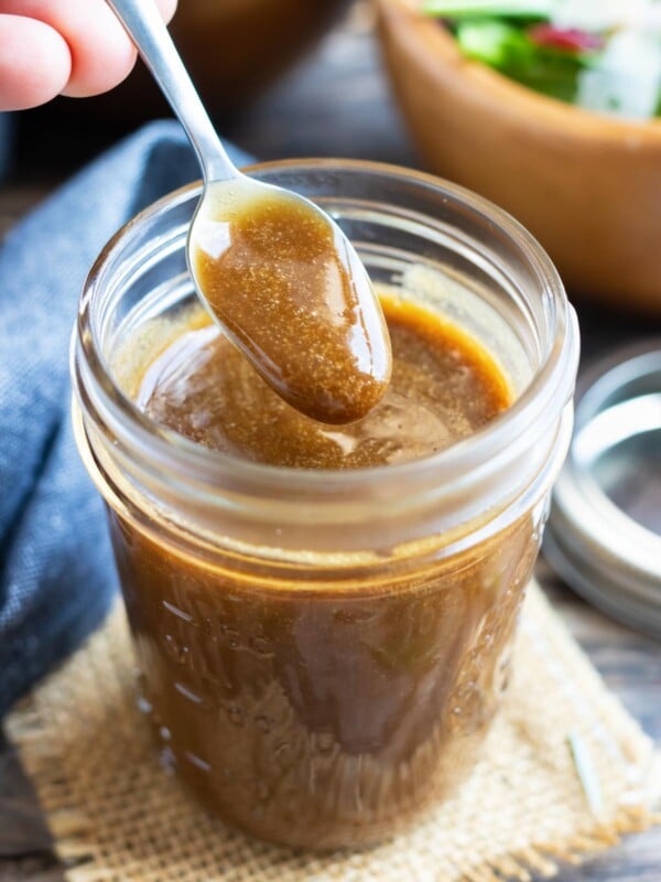 A small spoon scooping out a serving of a homemade balsamic salad dressing.