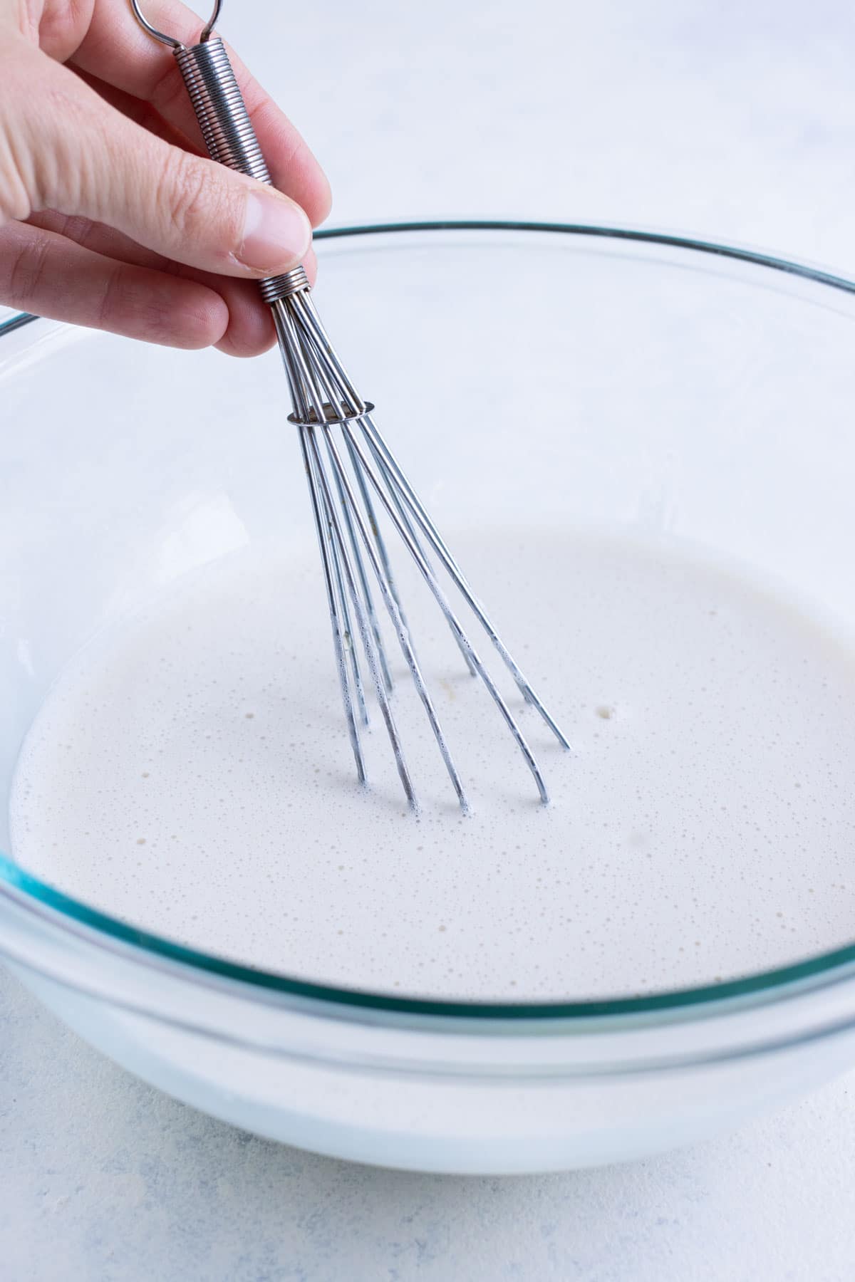 Milk, sweetener, and vanilla are mixed in a bowl.