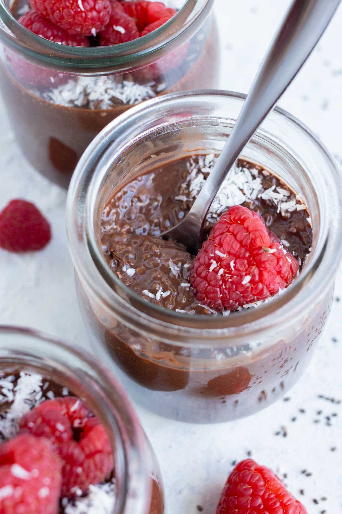 Chocolate chia seed pudding is topped with raspberries and shredded coconut.