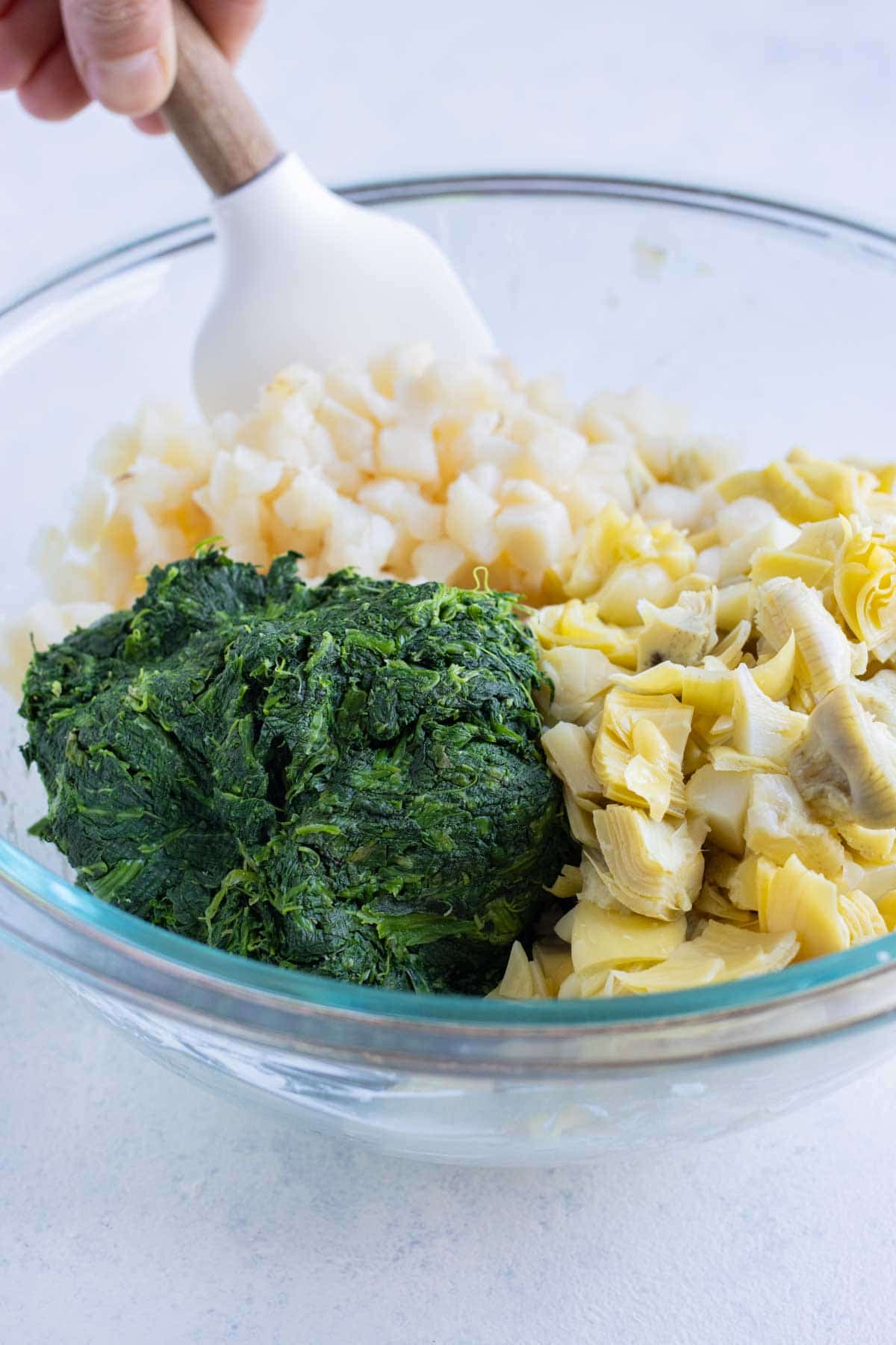 Spinach, water chestnuts, and artichokes are added to the mixture.
