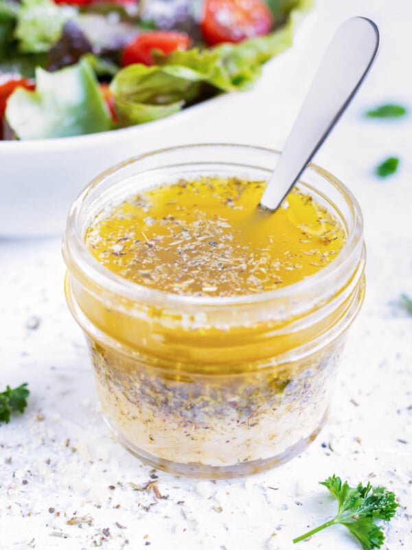 A small glass jar full of homemade Italian dressing that tastes like Olive Garden's.