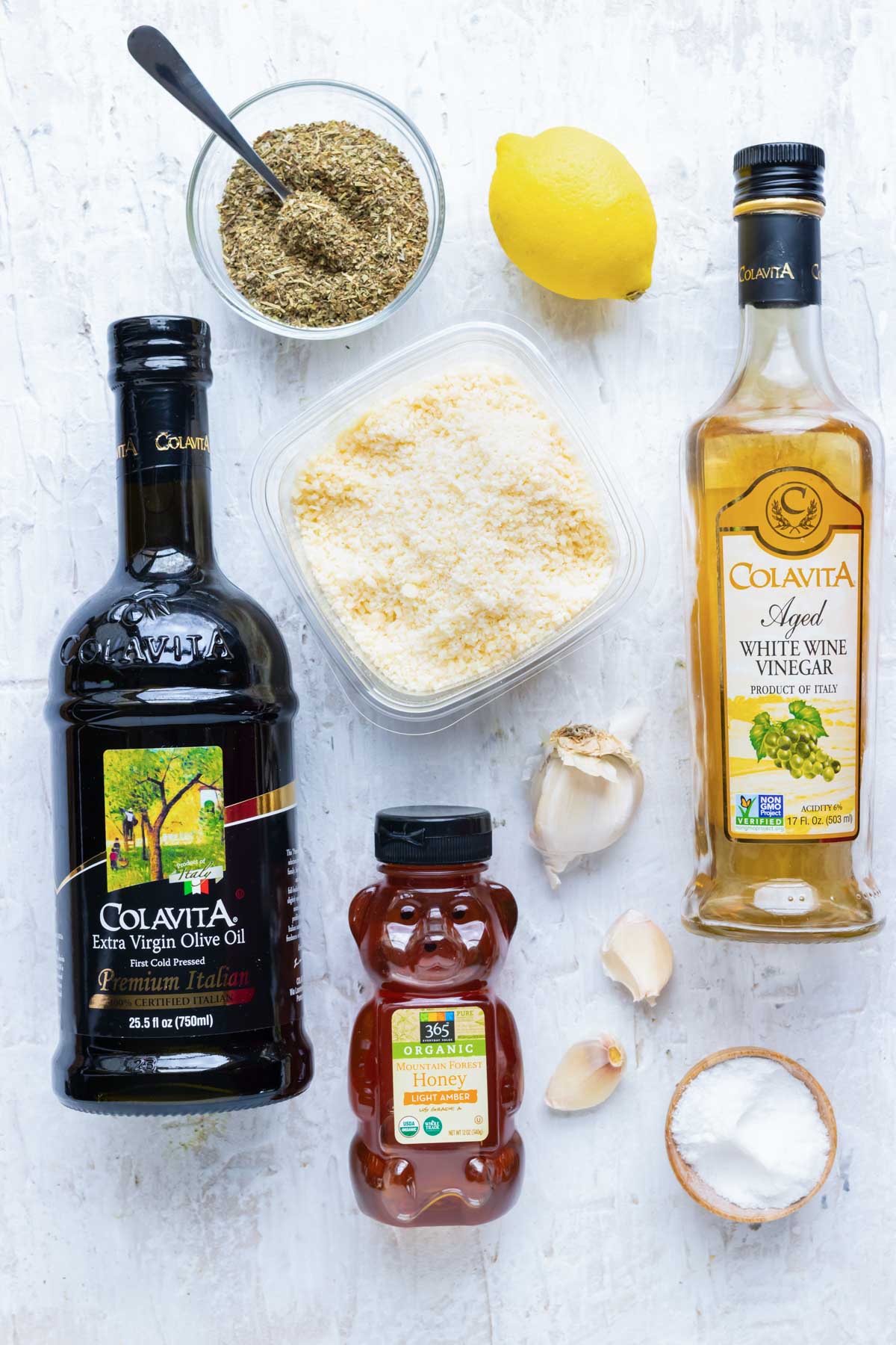 Olive oil, Parmesan cheese, honey, garlic, white wine vinegar, salt, lemon, and Italian seasonings as the ingredients for a homemade Italian dressing recipe.