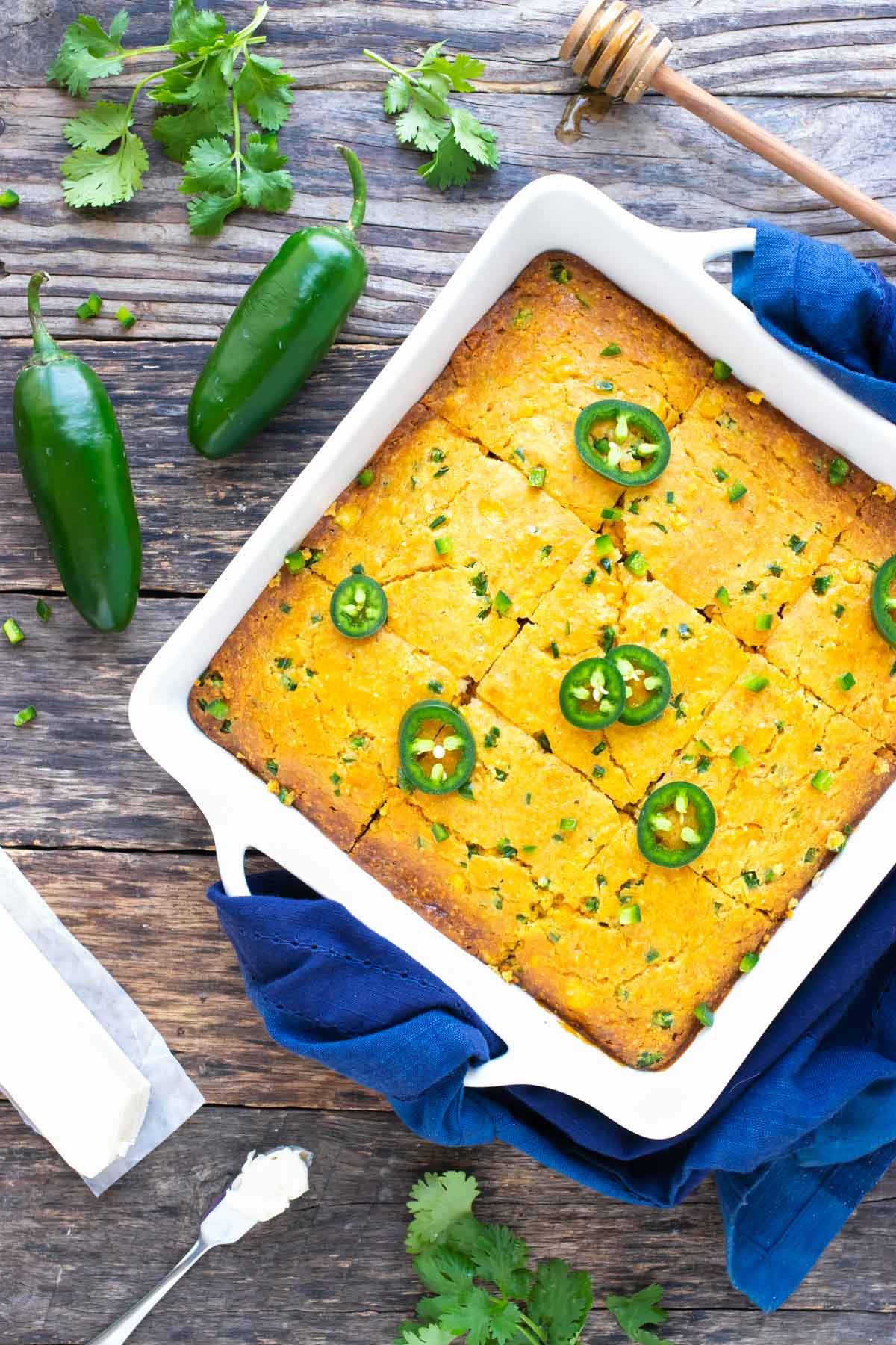 A white baking dish with a homemade cornbread recipe with jalapeños and corn.