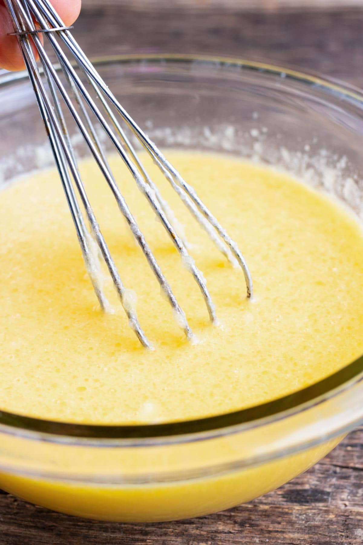 Wet ingredients being mixed together for a cornbread recipe.