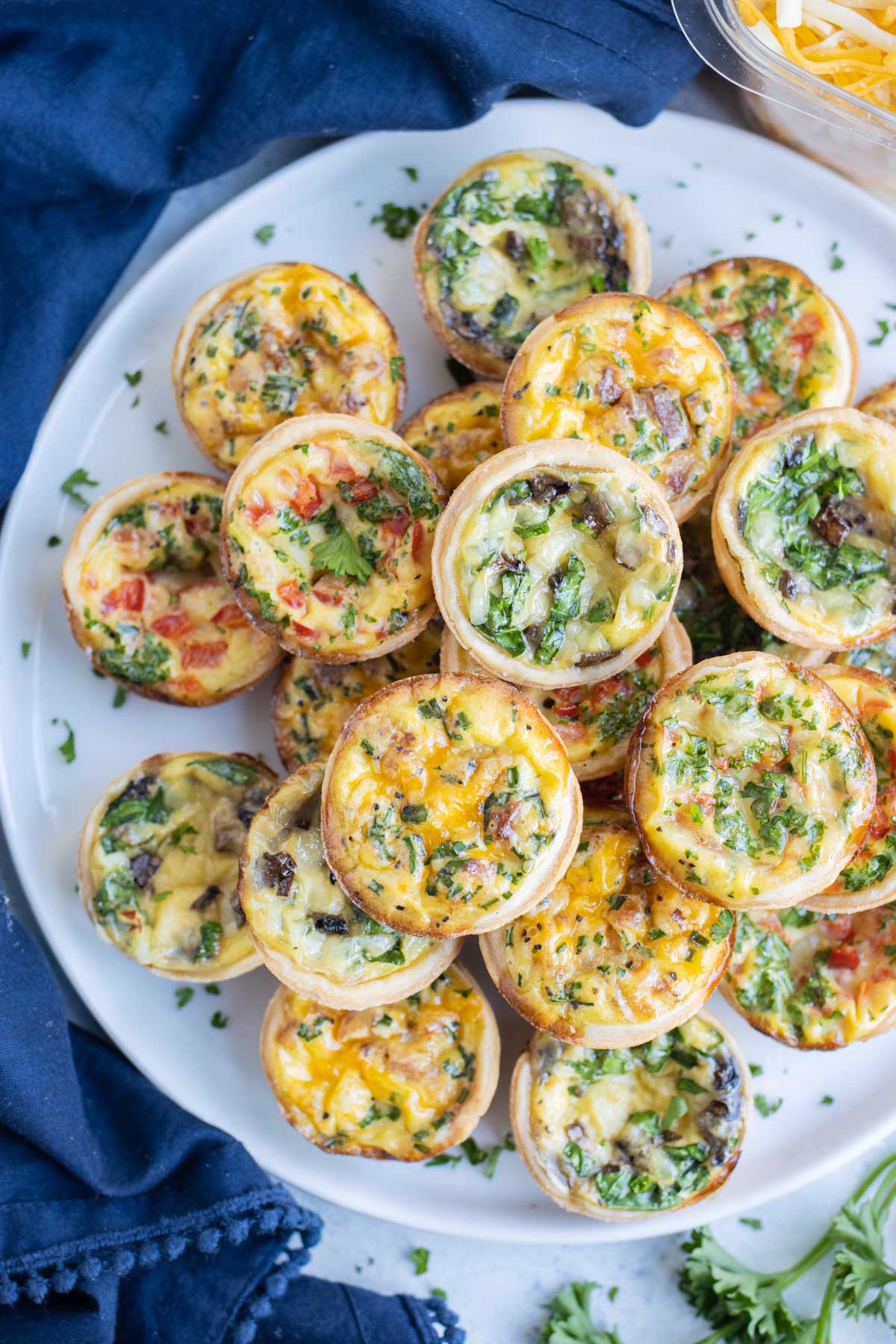 A white plate full of mini quiches.