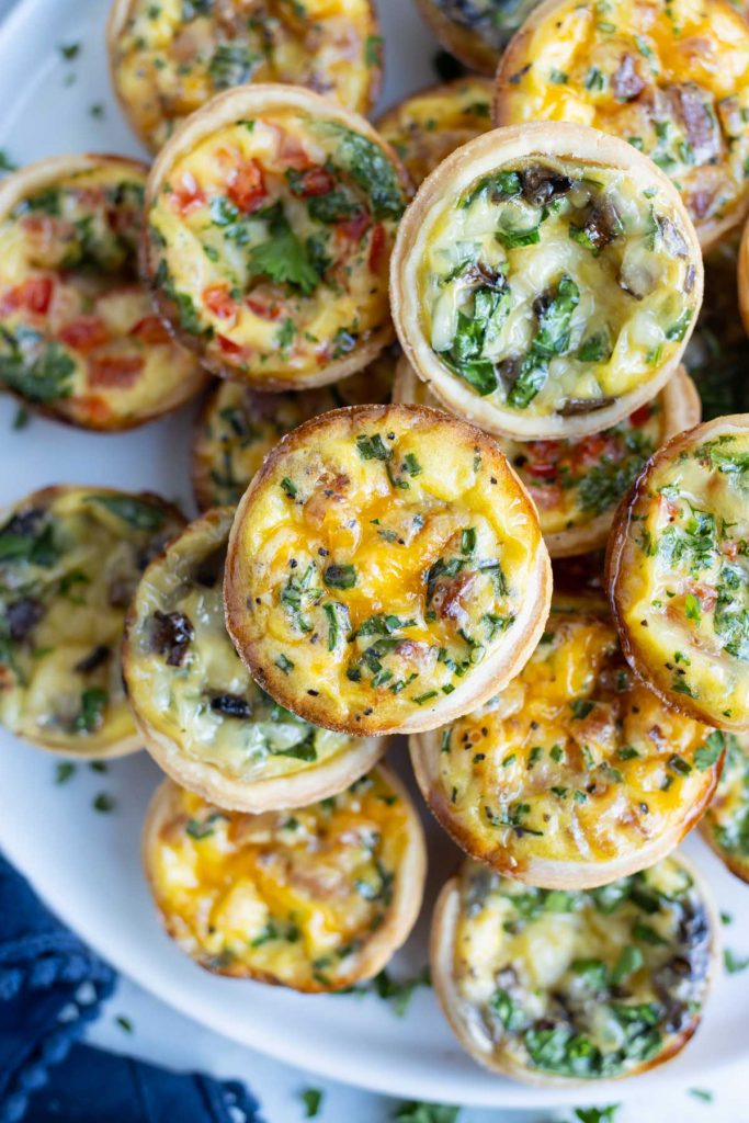 Mini quiches are served off a white plater.