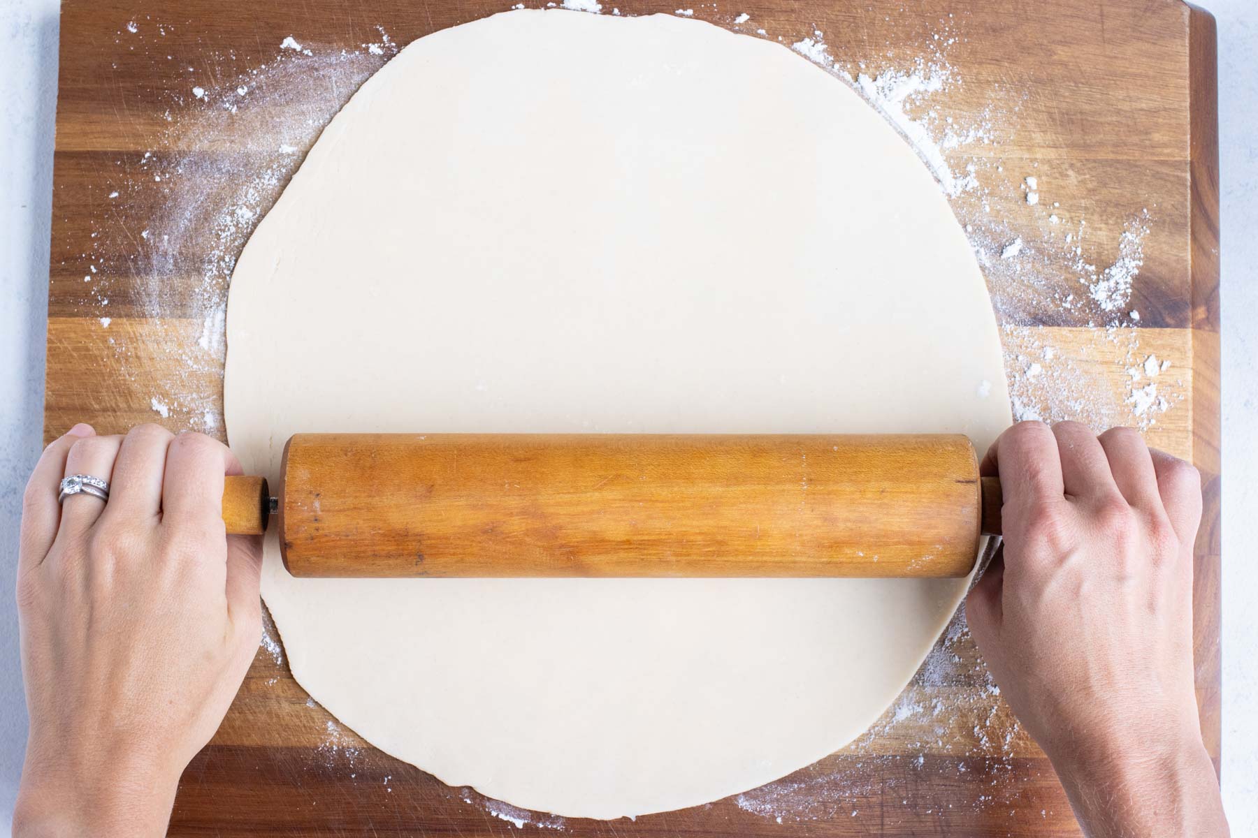 Pie crust is rolled out flat.