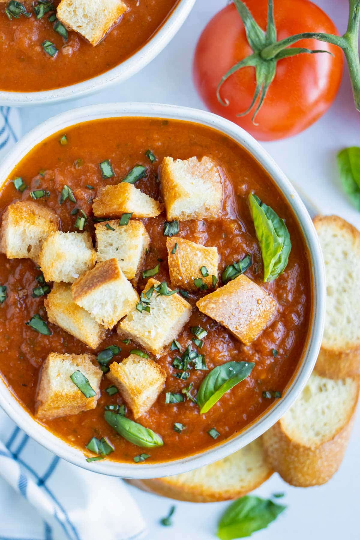 A creamy, vegan, whole30, and Paleo tomato soup recipe with fresh basil.