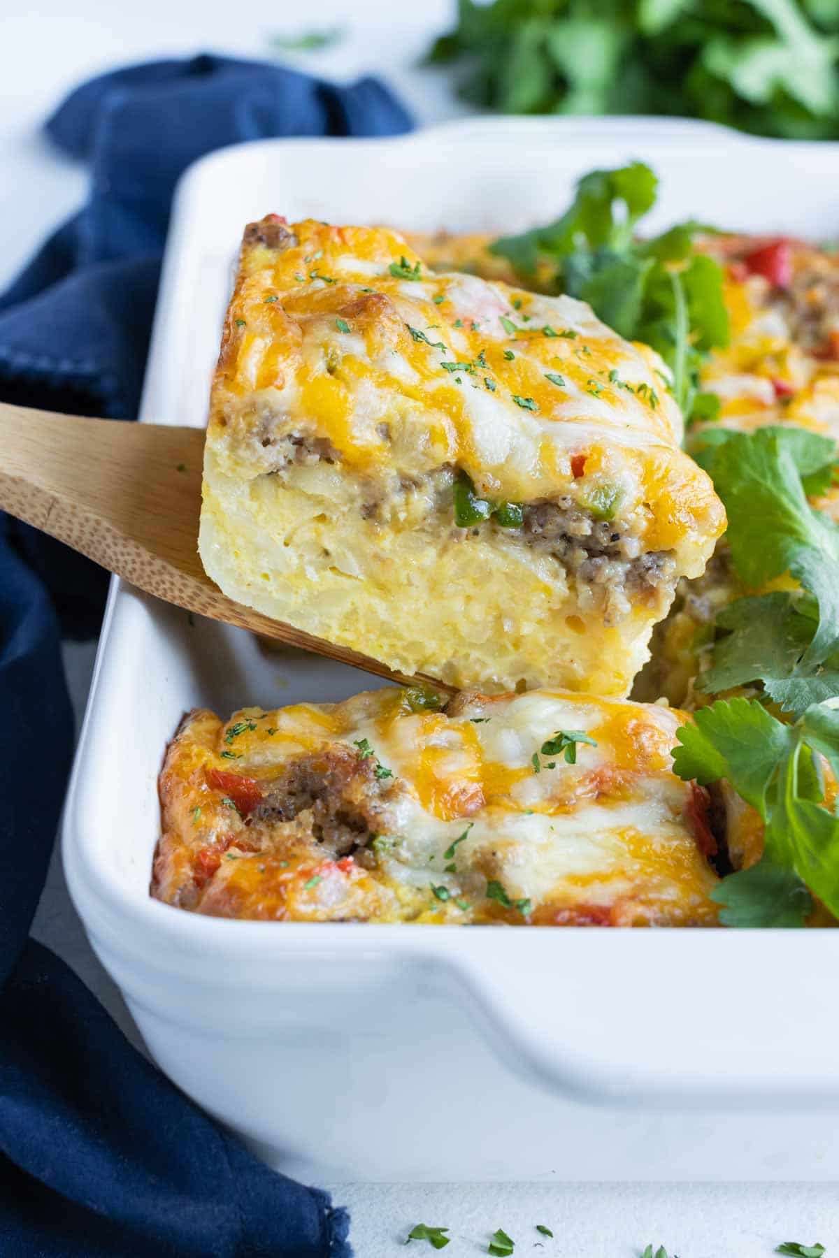 A piece of breakfast casserole is lifted out of the dish.