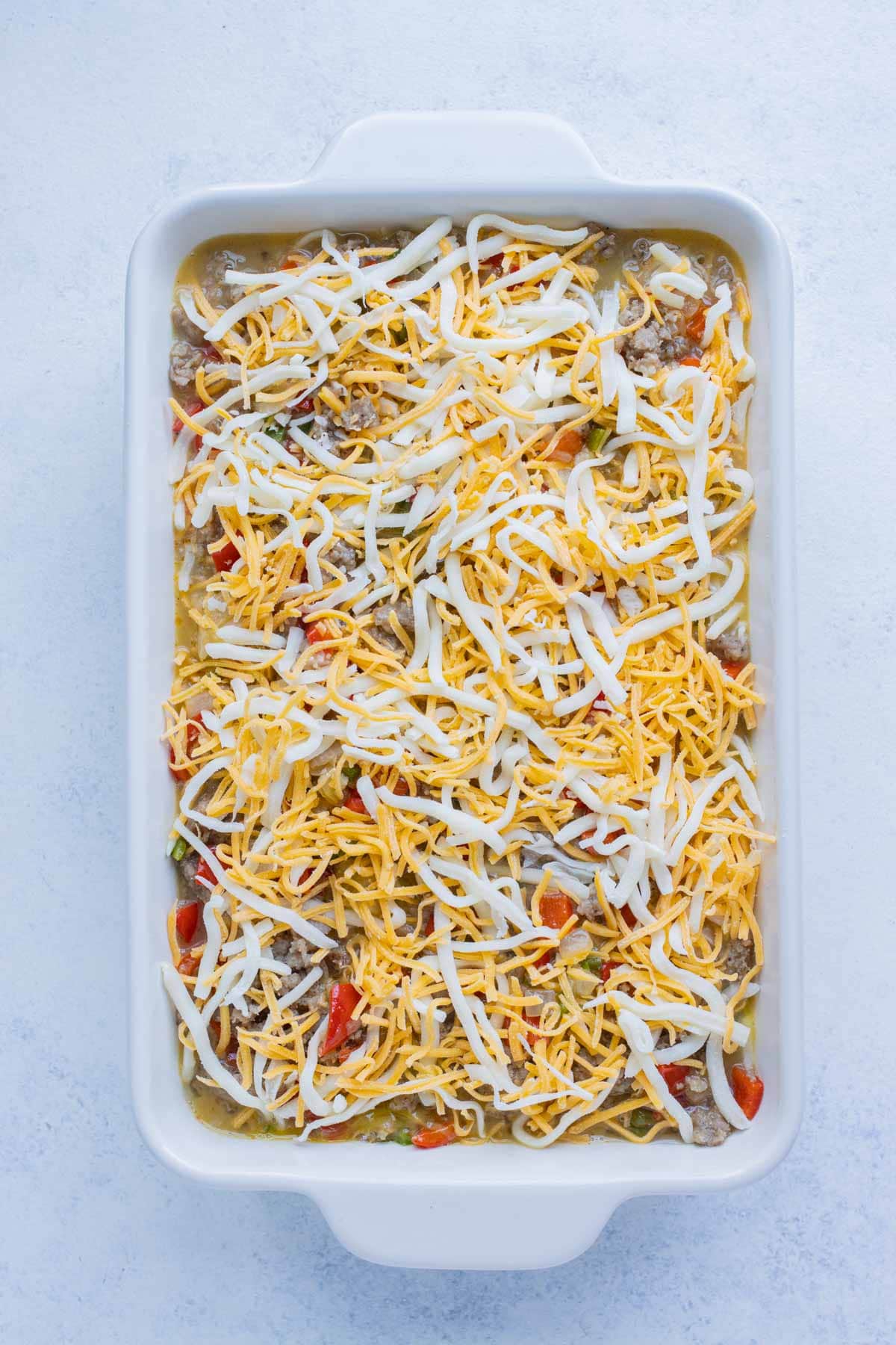 Cheese is spread over the top of the casserole.