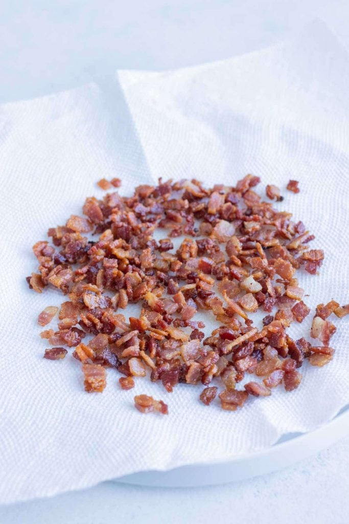 Bacon is removed from the pan and set on a paper towel.
