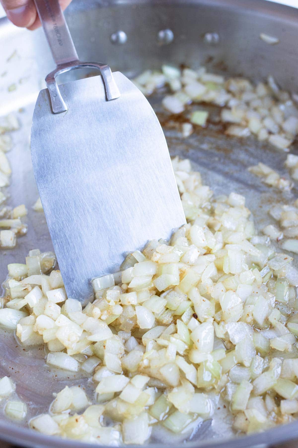 Diced onions are cooked on the stove.