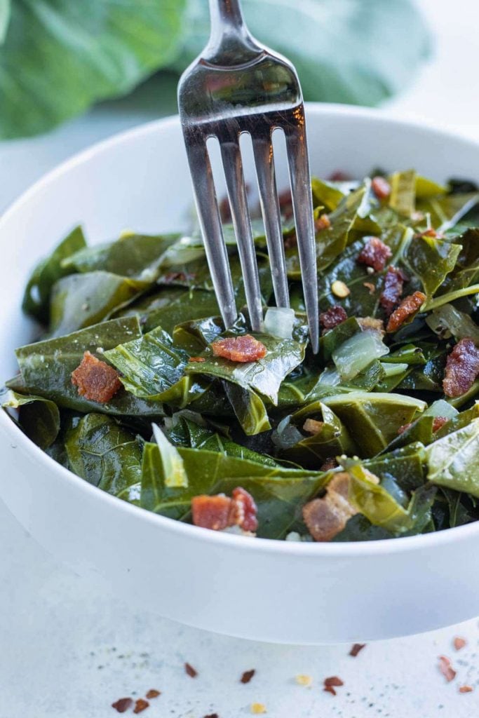 A fork is used to enjoy low-carb collard greens.