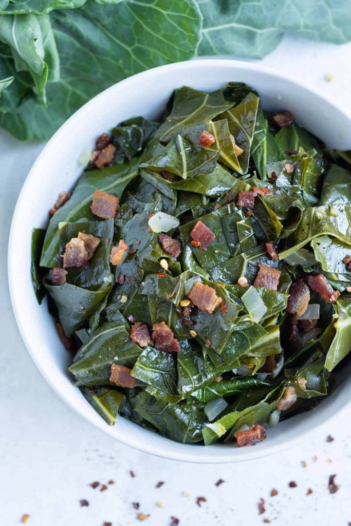 Collard greens and bacon are served in a bowl.