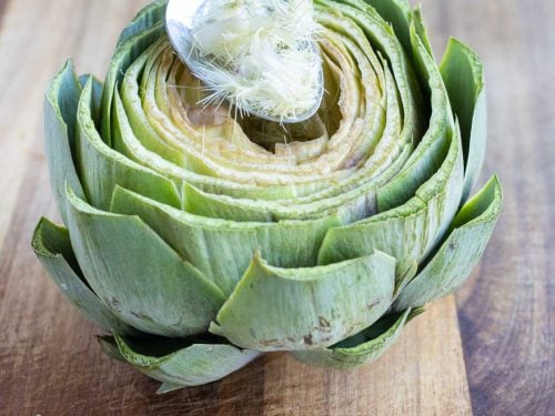 The fuzzy choke is removed from the center of the artichoke before stuffing.