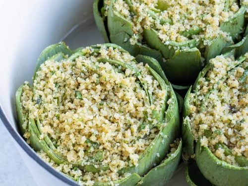 Stuffed artichokes are cooked in the oven in a dutch oven.