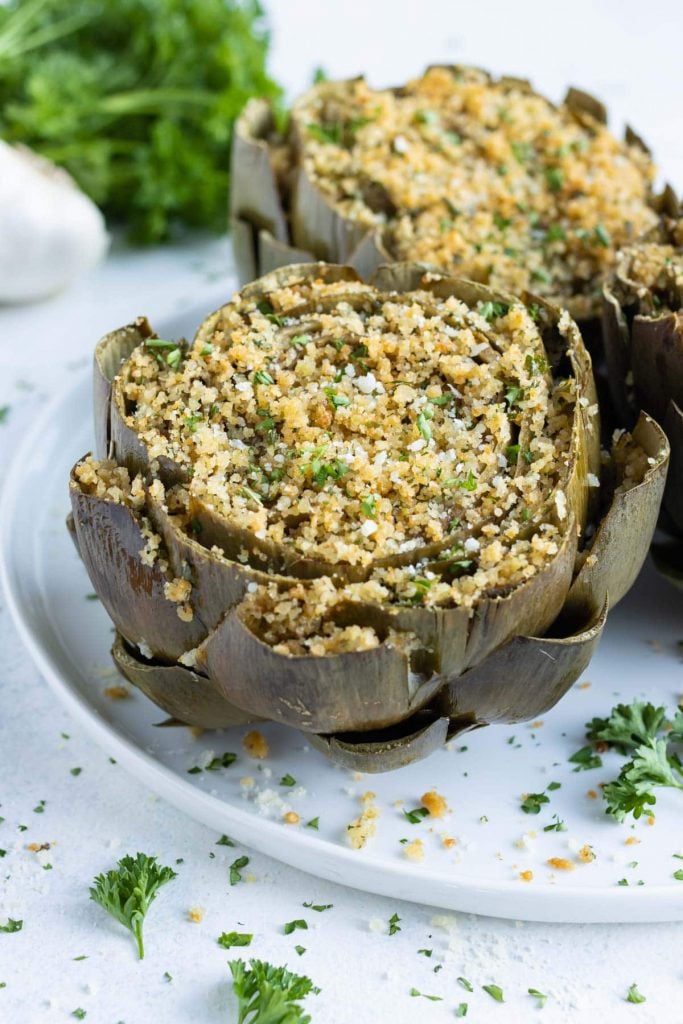 Oven-baked stuffed artichokes are eaten for a holiday appetizer.