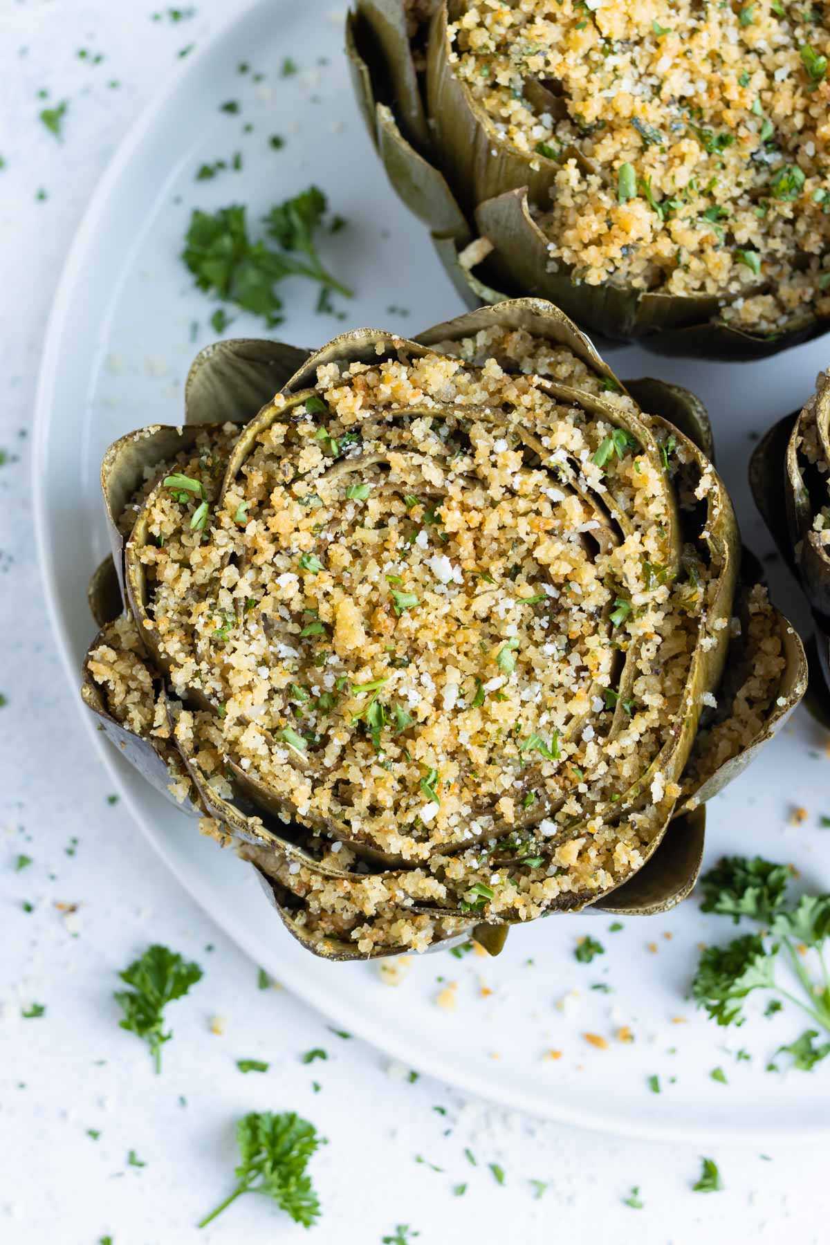 Italian Stuffed Artichokes are served on a white plate.