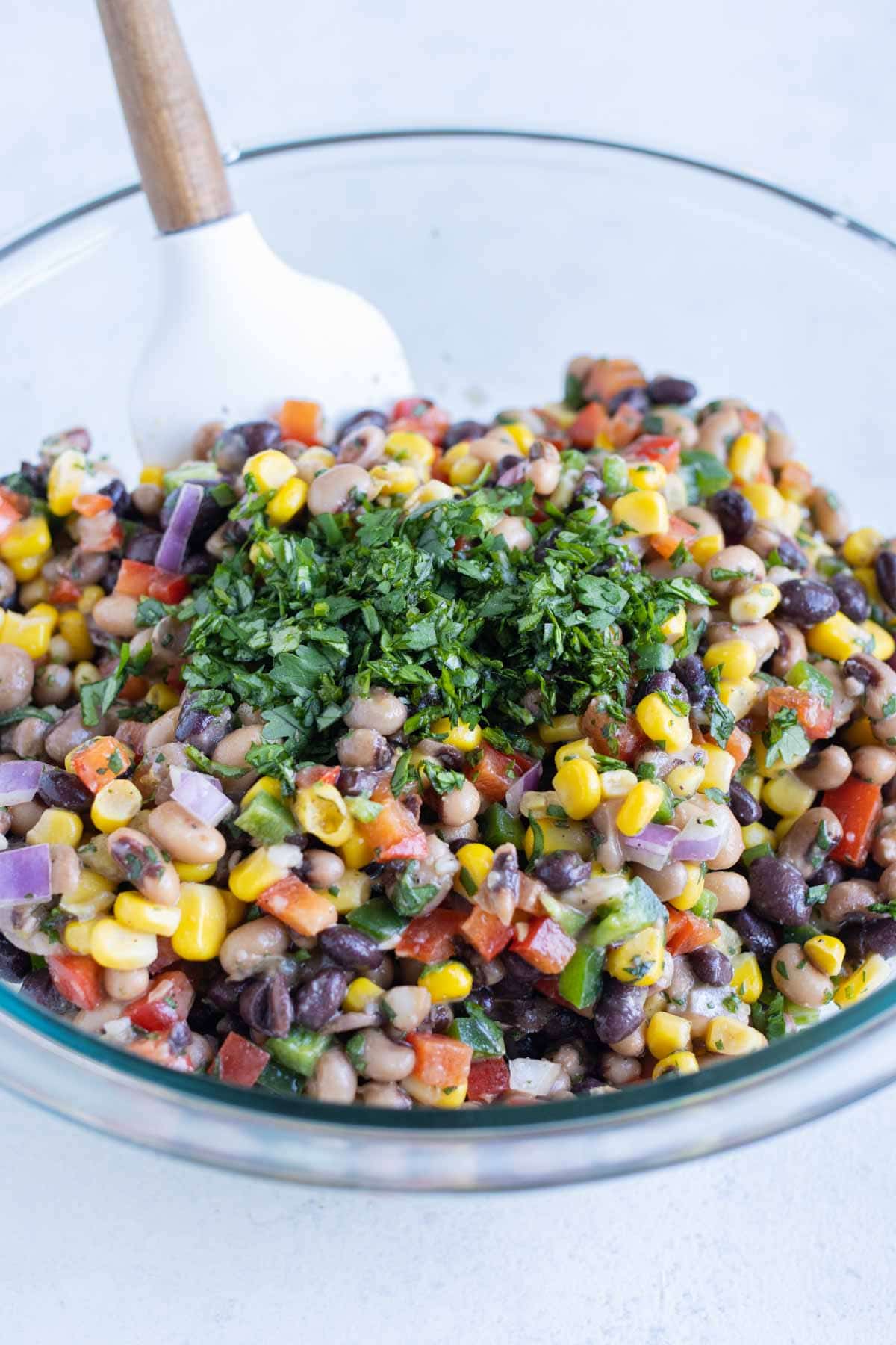 Chopped cilantro is added to the bowl.