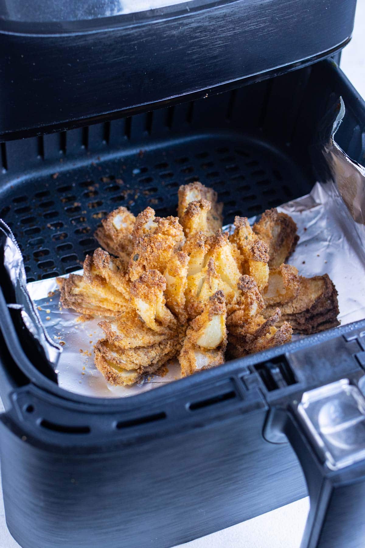 Blooming onion is cooked in the air fryer til golden.