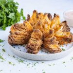 Air fryer blooming onion is plated for a crisp appetizer.