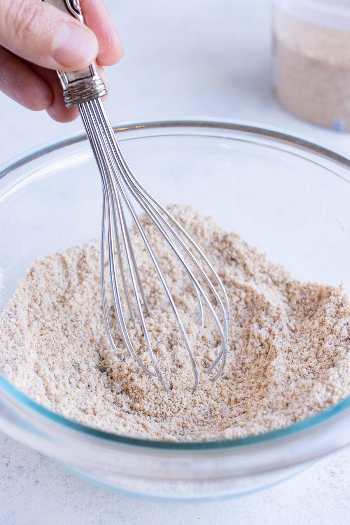 Dry ingredients are combined in a bowl with a whisk.