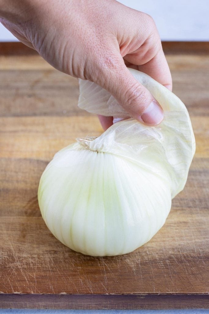 Paper thin skin peeled from the sweet onion for a copycat air fryer blooming onion.