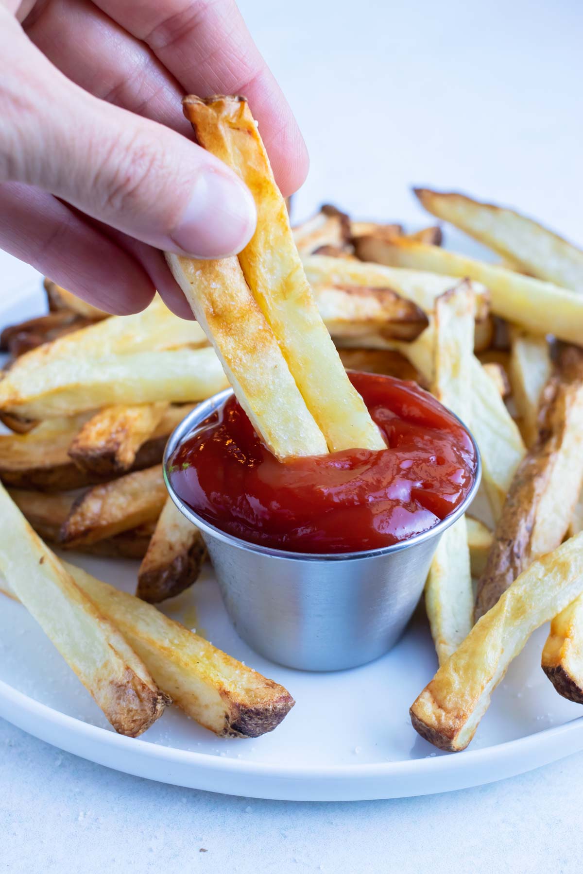 French fries are dipped in ketchup.