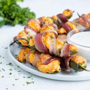 A plate is stacked with crispy jalapeno poppers for a low-carb appetizer.