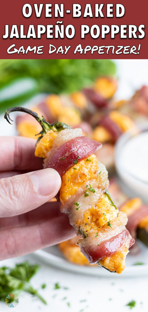 A bacon wrapped jalapeno popper is held up by a hand.