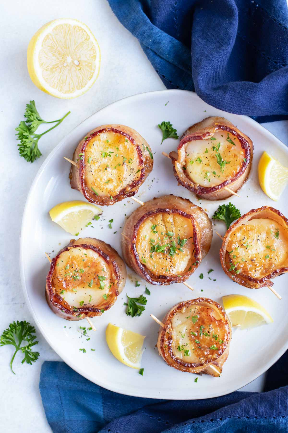 A plate full of bacon wrapped scallops to be served for a romantic Valentine's Day dinner.