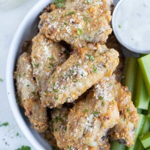 Parmesan garlic chicken wings are served on a plate.