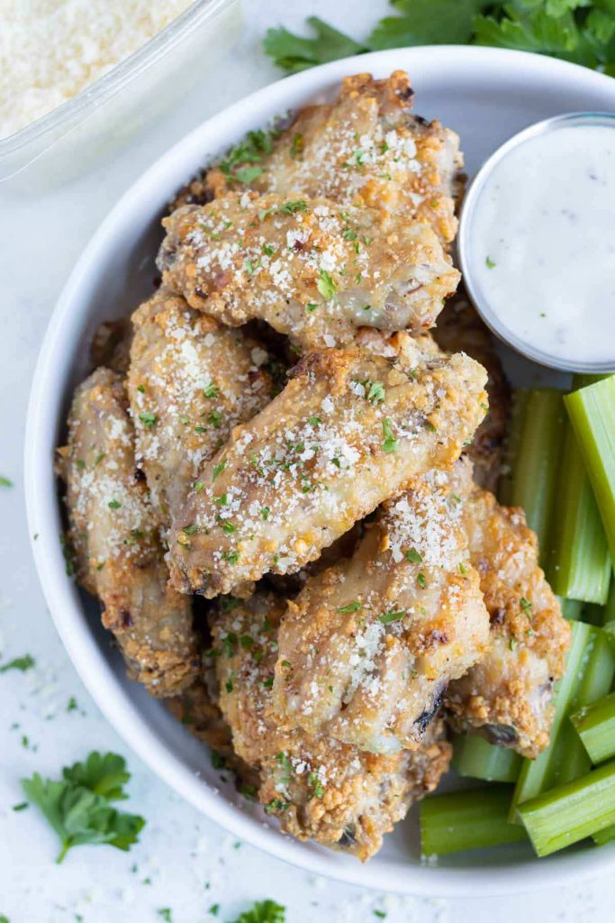 Parmesan garlic chicken wings are served on a plate.