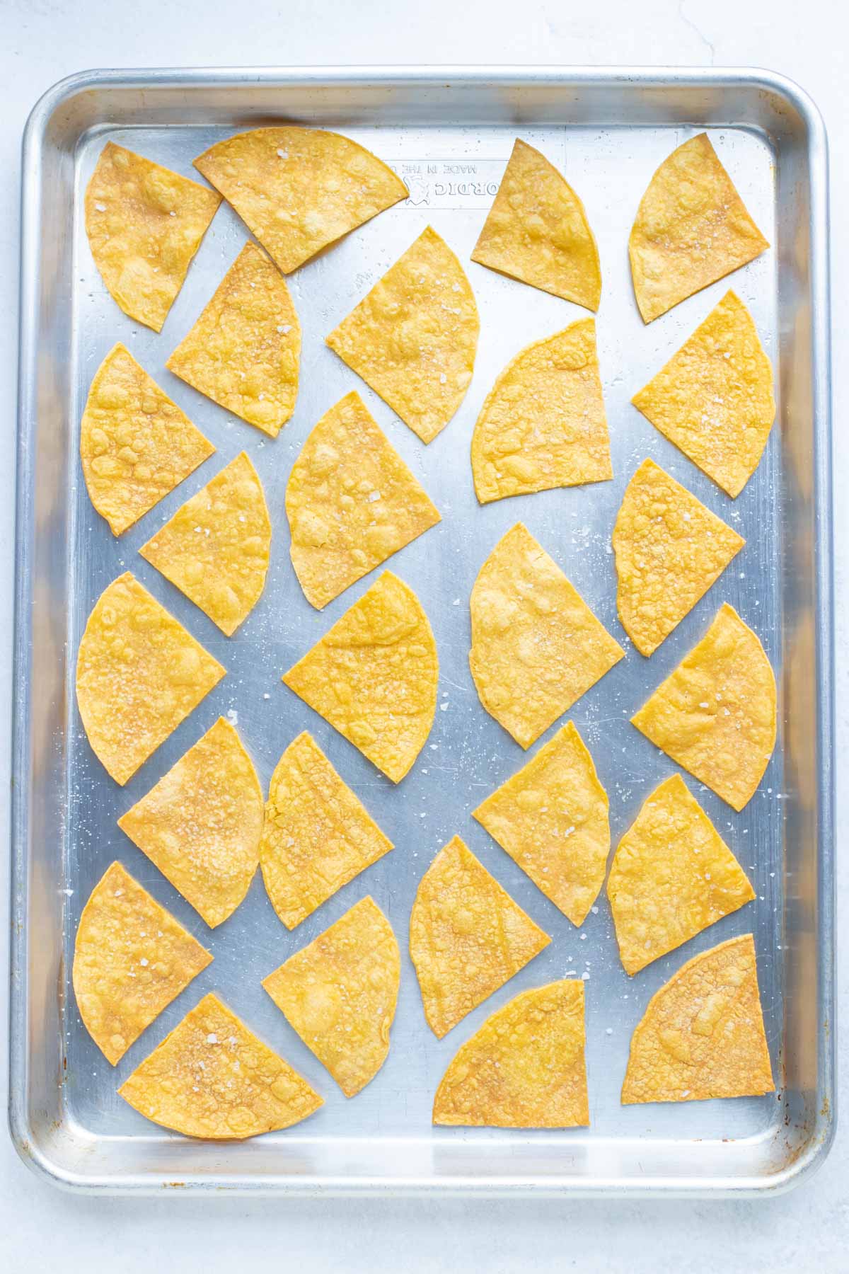baked tortilla chips on a baking sheet.