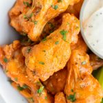 Buffalo chicken wings are served for a low-carb, healthy main dish on a plate.