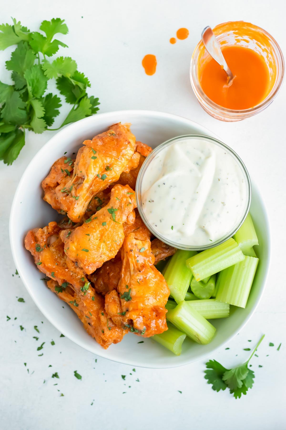 Baked buffalo chicken wings are served with blue cheese dressing and celery.